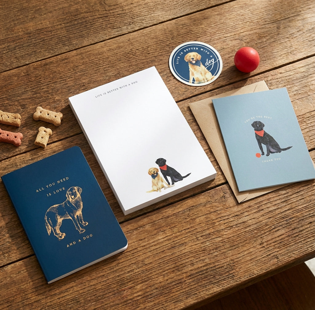 Notebooks and stationery items with dog illustrations on a wooden surface